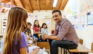 Teacher talking to elementary school children and motivates them to learn new subjects